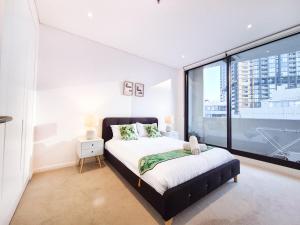 悉尼Cozy Apartment at St Leonard的一间卧室设有一张床和一个大窗户