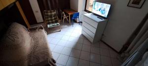 蓬泰迪莱尼奥GRAYNITE-Old Village Apartment的一间配有电视的卧室和瓷砖地板