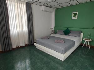 科伦坡帕尔米拉住宅酒店的一间卧室设有一张床和绿色的墙壁