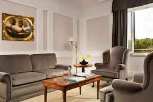 罗马Hotel Splendide Royal - The Leading Hotels of the World的客厅配有沙发、两把椅子和一张桌子