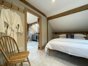 霍舍姆Lancasters Cottage的一间卧室配有一张床和一把椅子