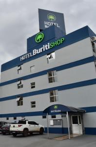 戈亚尼亚Hotel Buriti Shop的门前有车辆停放的酒店