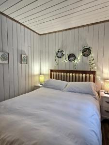 Rivière-RougeAlison On Lake & Romantic Getaway With Private Hot Tub的卧室配有一张白色大床,墙上挂着灯