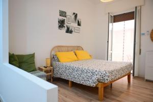 阿拉西奥Casina Da Vinci, monolocale ecosostenibile的一间卧室配有一张带黄色枕头的床。