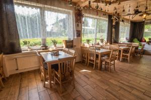 拜尔里舍艾森施泰恩Pension Arberwald的餐厅设有木桌、椅子和窗户。