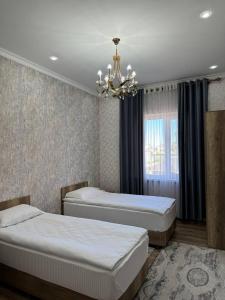 博孔巴耶沃Айкол的一间卧室配有两张床和吊灯。