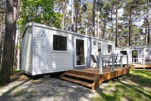 奥斯特巴德·哥伦Kleines aber feines Ferienhäuschen in Strandnähe - Tiny Chalet Nr 816的白色的小房子,配有桌子和椅子