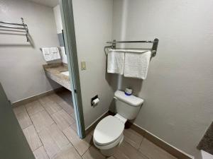 艾达Budget Inn Ada的浴室设有卫生间、水槽和毛巾