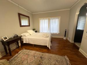 贺茂沙海滩The Vurpillat的一间卧室配有一张床、一张桌子和一个窗户。