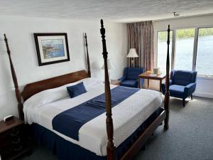 Bucksport诺克斯堡宾馆的一间卧室配有一张床和两张蓝色椅子