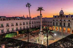 阿尔么丽亚Estrena Apartamento en centro historico de Almeria的一座白色的大建筑,前面有棕榈树