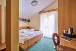 维哥迪法萨Berg Hotel Latemar Spitze的酒店客房设有床和窗户。