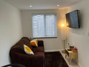 KentElmwood Lodge的客厅设有棕色的沙发和窗户。