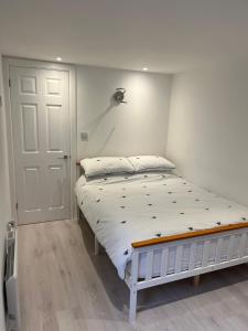 KentElmwood Lodge的一间卧室配有一张白色床架的床
