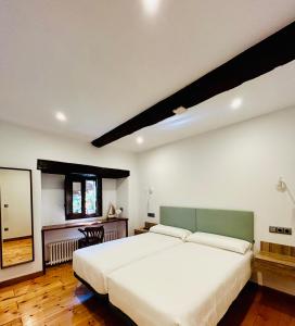 利亚内斯茹拉勒阿克拉公寓的卧室配有一张白色大床和镜子