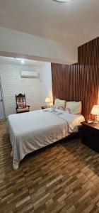 圣多明各Hotel Cana Palma Zona Colonial的一间卧室设有一张大床,铺有木地板
