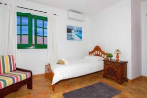 阿里亚Casa Crisana的卧室配有床、椅子和窗户。