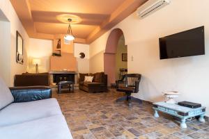 帕琉乔拉Villa Araxovoli的客厅配有沙发和墙上的电视