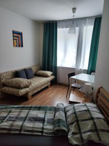 维也纳Hostel&ApartServices Viennna The Tidy Apartment的一间卧室配有一张床、一张沙发和一张桌子