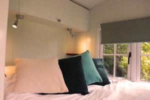 奇切斯特Cobo Cottage的卧室配有带枕头的床铺和窗户。