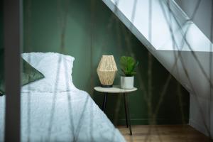 洛里昂Jungle Urbaine的一间卧室配有一张床和一张植物桌子