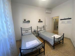 比萨Ad Agio Apartments的走廊的客房内设有两张单人床。