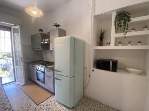比萨Ad Agio Apartments的厨房配有白色冰箱和炉灶。