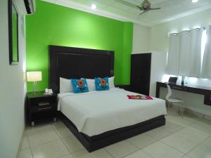 图斯特拉古铁雷斯Chiapas Hotel Express的一间卧室设有一张床和绿色的墙壁