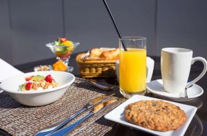 旧金山旧金山康福特湾酒店的一张桌子,上面有早餐食品和一杯橙汁