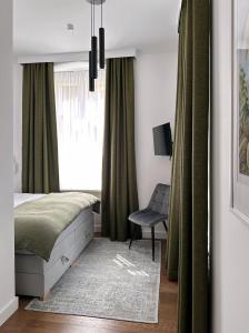 隆代克-兹德鲁伊Apartament Miła 2的卧室配有床、椅子和窗户。