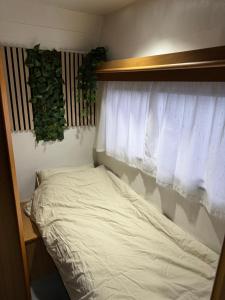 凯夫拉维克Camping Van的窗户和床罩的房间里的一个床位