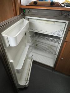 凯夫拉维克Camping Van的厨房里空着冰箱,门开
