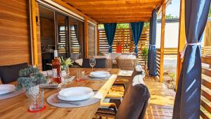 比奥格勒·纳·莫鲁Mobile Homes Jaki - Camp park Soline的一间带木桌和椅子的用餐室