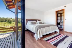 普耶韦Orilla de Lago con Hot Tub, parrilla y vistas的一间卧室设有一张床和一个阳台