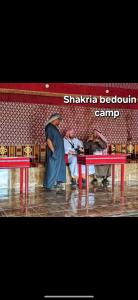 瓦迪拉姆Shakria Bedouin Life Camp的一群人站在一张红桌旁