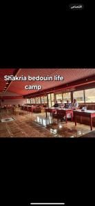 瓦迪拉姆Shakria Bedouin Life Camp的一群坐在大楼野餐桌上的人