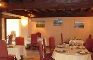 卢昂木林德布尔城堡酒店的一间设有白色桌子和红色椅子的餐厅
