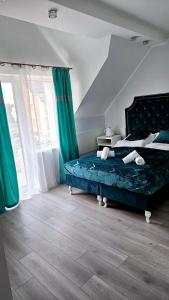 卡尔维亚Solar Bed & Breakfast的一间卧室配有一张带蓝色床单和绿色窗帘的床