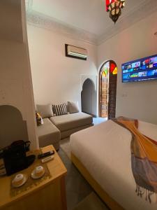 马拉喀什RIAD KECHMARA的客厅配有床和沙发