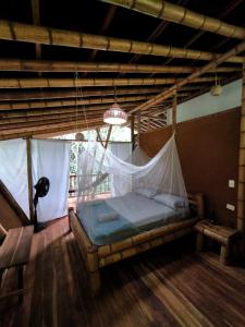 伯里塔卡Finca La Selvita的配有蚊帐的客房内的一张床位
