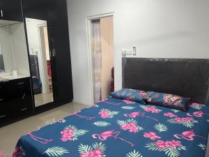 南迪Island Guesthouse - entire one bedroom unit with kitchen & a bathroom centrally located in Votualevu的一张带蓝色棉被和黑色床头板的床