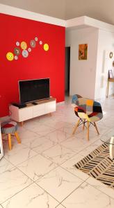 莱特鲁瓦西莱Maison Indép, Spa, Mer, Jardin, Bien-être的客厅设有红色墙壁和平面电视