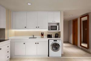 马斯喀特Levatio Suites Muscat, a member of Radisson Individuals的厨房配有洗衣机和微波炉。