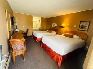 穆斯乔穆斯乔旅程住宿汽车旅馆的酒店客房配有两张床和一张书桌