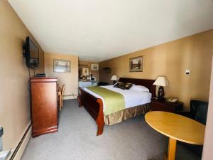 穆斯乔穆斯乔旅程住宿汽车旅馆的酒店客房配有一张床铺和一张桌子。
