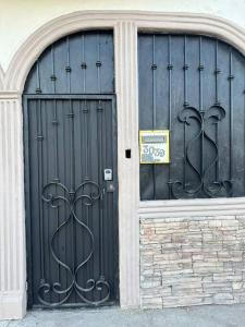 墨西卡利Casa en Mexicali的建筑物上两扇黑色门,上面有标志