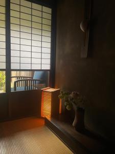 京都Azukiya的一间有桌子的房间和一个花瓶