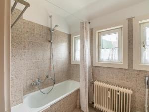 施马伦贝格Kurhaus am Nordenau的带浴缸的浴室和窗户。
