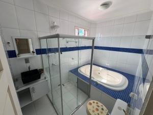 帕里普埃拉Pousada e Restaurante Mar dos Sonhos的一间带玻璃淋浴和水槽的浴室