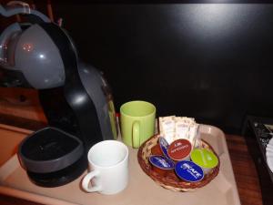 蒙特韦尔迪Monte Verde Inn Suítes com Hidromassagem dupla的咖啡壶和一碗饼干及咖啡杯